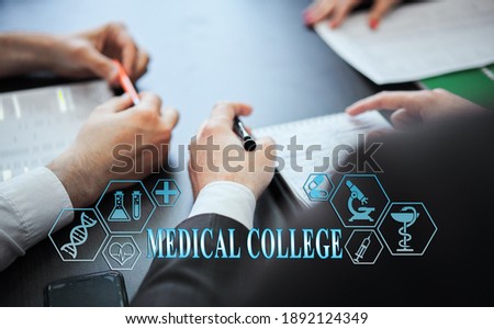 A group of doctors in a modern clinic is planned. The concept of modern medicine and medical biotenology. Medical icons on the screen with the inscription: MEDICAL COLLEGE