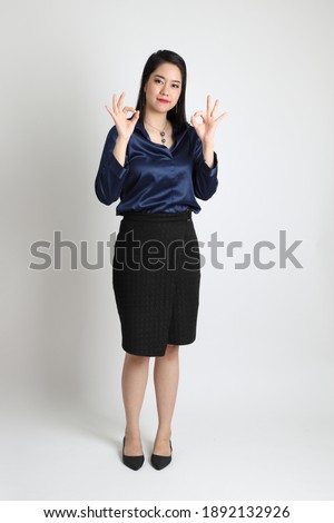 The Asian business woman standing on the white background.