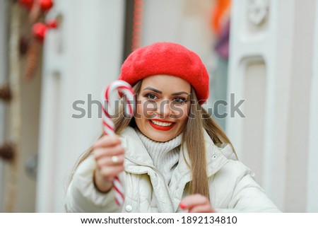 Christmas shopping. Young woman holding a Christmas lollipop. Holidays.