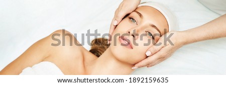 Face massage at spa salon. Doctor hands. Pretty female patient. Beauty treatment. Healthy skin procedure. Young woman head. Light background. Scrub rejuvenation. Facial dermatology mask. Detox therapy Royalty-Free Stock Photo #1892159635