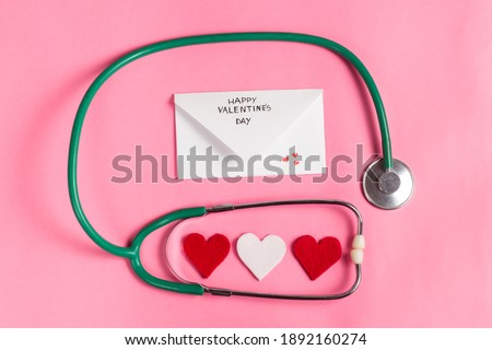 Valentine's day medical composition. Red hearts and love message next to the stethoscope. Covid-19 Valentine's day. Valentine's day for medical workers. Image for pharmacy, hospitals, medicine