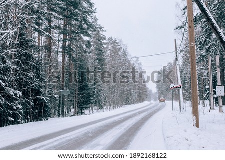 Countryside road through the forest  in winter with snow 