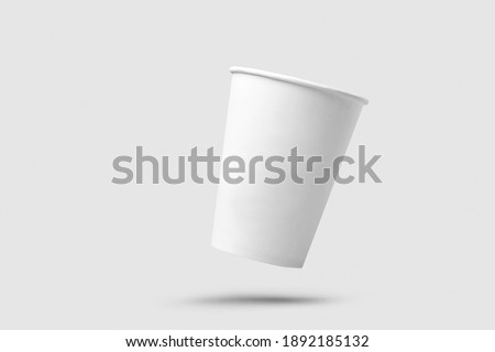 White paper cup of coffee on light grey background.  Flying paper cup on white background. Isolated for mock up