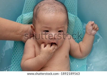 Portrait image of happy Asian Chinese baby boy being bathed
