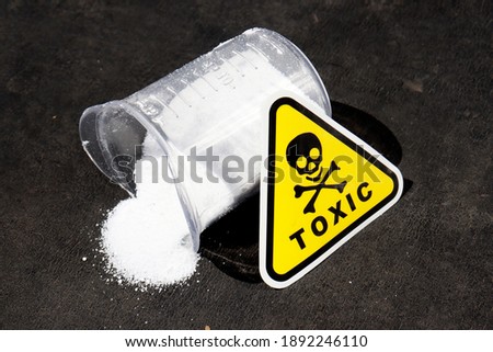 white toxic powder on a black background. a handful of toxic powder. toxic washing powder