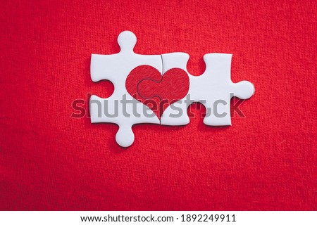 Heart shaped puzzle pieces love valentine concept for valentines day and sweetest day on red gift box background Royalty-Free Stock Photo #1892249911