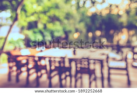 Vintage tone abstract blur image of  Outdoor Restaurant  in garden with green bokeh for background usage .