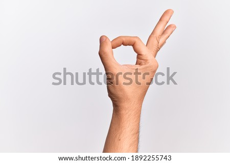 Hand of caucasian young man showing fingers over isolated white background gesturing approval expression doing okay symbol with fingers