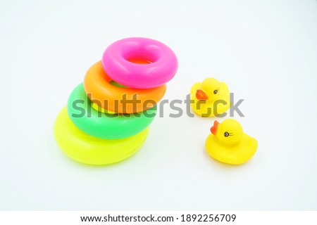Orange duck toy and colorful circles on a white background