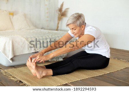 beautiful adult woman doing yoga at home Royalty-Free Stock Photo #1892294593