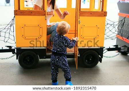 Little boy goes to mother.
Little boy trying to enter the children's trailer to the mother