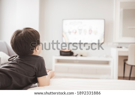 Little boy watching television at home. Copy space. Soft focus.