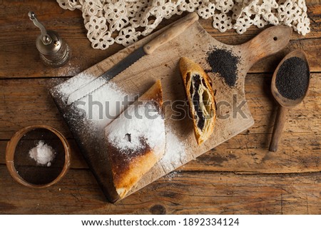 Poppy seeds home made strudel (Mohnstrudel),rolled layered pastry stuffed inside baked yeast dough crust,tasty holiday dessert pie,traditional European balkan cuisine recipe using organic ingredients