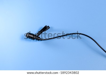 Lavalier microphone on a blue background.