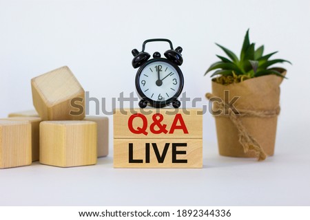 Q and A, questions and answers live symbol. Concept words 'Q and A live' on wooden blocks on a beautiful white background. Black alarm clock and house plant. Business and Q and A live concept. Royalty-Free Stock Photo #1892344336