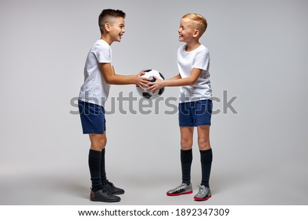 two soccer players 10 years old beginning soccer game, hold match. studio portrait