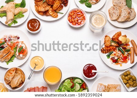 Buffet service. Frame of different dishes on white wooden table, space for text