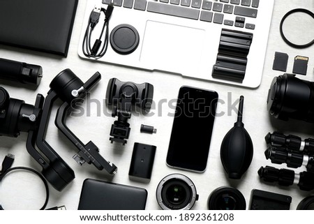 Camera equipment and accessories for video production on light background, flat lay