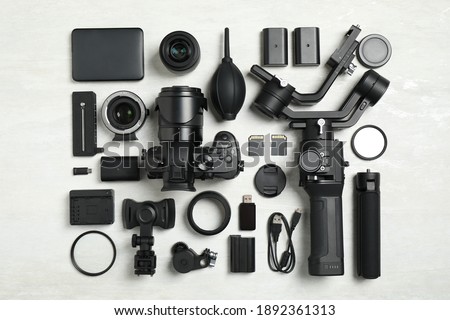 Flat lay composition with camera and video production equipment on light background