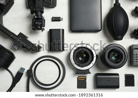Flat lay composition with camera equipment and accessories for video production on light background