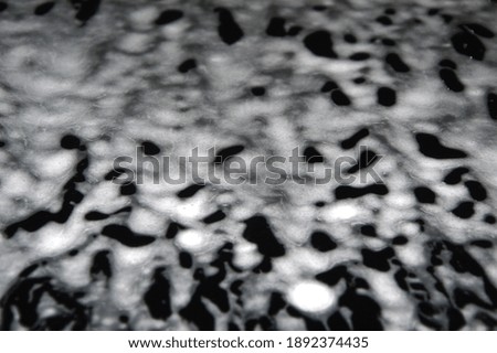 Texture of drops of foam flowing down a sheet of metal