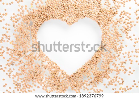 heart made of raw lentils on white background, healthy life and nutrition concept