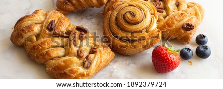 Bakery pastries, strawberries on marble table. Freshly cooked bakery. Home cooked bakery for morning breakfast. Royalty-Free Stock Photo #1892379724