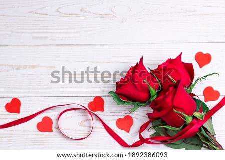 Valentin day romantic flat lay top view image. Red roses bucket with red ribbon and little heart on white background.