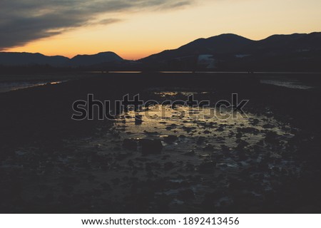 Beautiful sunset over lake in the winter.Mountains in background. High quality photo.