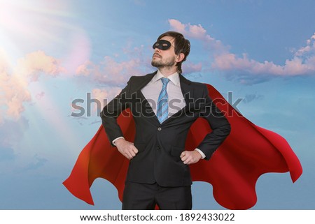 Funny brave businessman in suit as superhero. Sky in background.