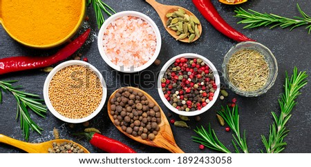 Assortment of aromatic organic spices and herbs on black rustic background close up. Healthy food concept. Royalty-Free Stock Photo #1892433058
