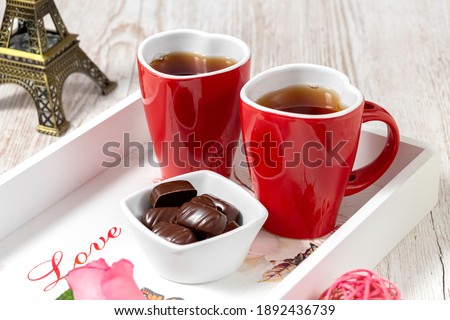 Two heart-shaped cups and chocolate on a white rustic tray.Breakfast for lovers. Valentine's Day. Postcard.