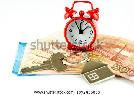 house key and red alarm clock, the concept of a home purchase