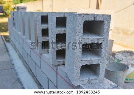 a worker builds a cinder block wall for a new home Royalty-Free Stock Photo #1892438245