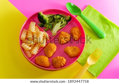 At home schooling chicken nugget lunch served on tray with french fries and broccoli Royalty-Free Stock Photo #1892447758