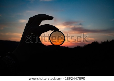 Hand Holding filter lens camera, sunset, mountain, landscape