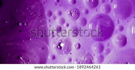 beautiful background of paint bubbles floating on water with mix of oil purple