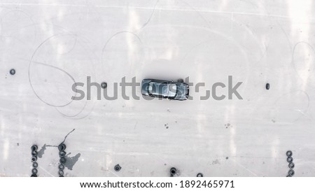practical driving test. student on a black car bypasses obstacles. slalom by car between tires. aerial view. driving training area, driving course. Driving lessons training. top shot Royalty-Free Stock Photo #1892465971
