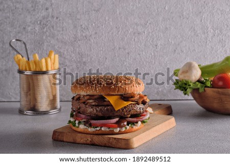 thick cheeseburger with american cheese, lettuce tomato, onion and mushroom with fries