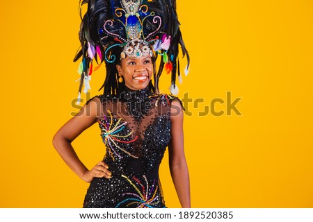 Brazilian afro woman posing in samba costume over yellow background with free space 
