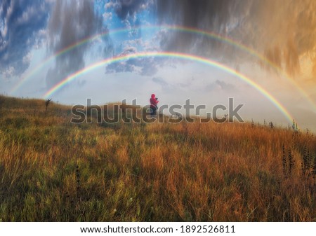 Woman Looking At Rainbow. rainbow over the autumn river