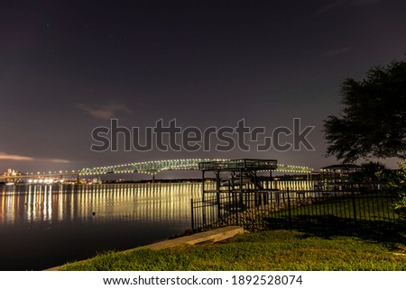 Lights on a bridge reflect off the St Johns river at night Isaiah David Hart Bridge