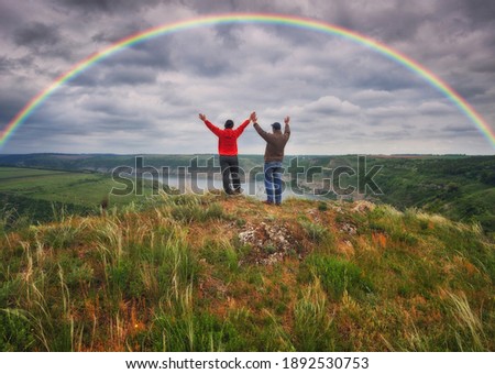 Woman and man Looking At Rainbow. rainbow over river canyon
