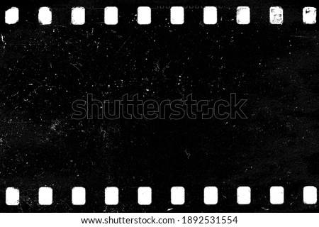 Dusty and grungy 35mm film texture material or surface. Dust particle and grain texture or dirt use for overlay film frame effect with space for vintage grunge design. 