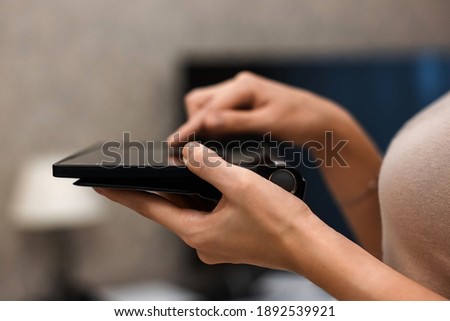 A female hand presses on the screen of a digital tablet close-up, side view. New technology concept, multimedia. soft focus