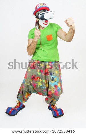 Holiday and fun concept. The clown plays, he has virtual glasses on his head, fights. Isolated on white