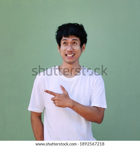 Asian man looking top view and finger point to side view for sale promotion