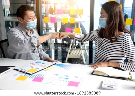 two business people use hand to fist bump for succes teamwork coporate Partner Business Businessman  wearing a mask not to risk COVID-19 the new coronavirus in the concept new norma Royalty-Free Stock Photo #1892585089
