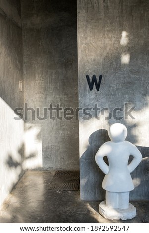 Symbol woman white statue in front of the women restroom, Restroom sign, Toilets icon.