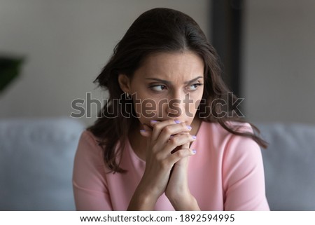 Worried unhappy young indian Arabic woman look in distance window thinking or pondering over problem solution. Upset sad millennial middle eastern female lost in thoughts, feel anxious at home. Royalty-Free Stock Photo #1892594995